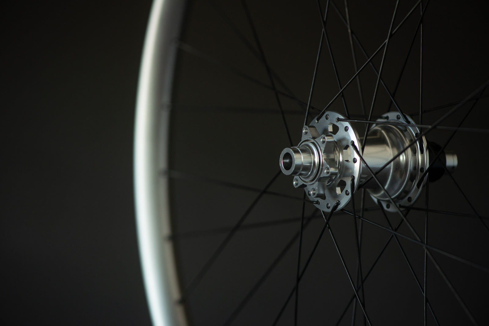 Close-up of a bicycle wheel hub with spokes against a dark background